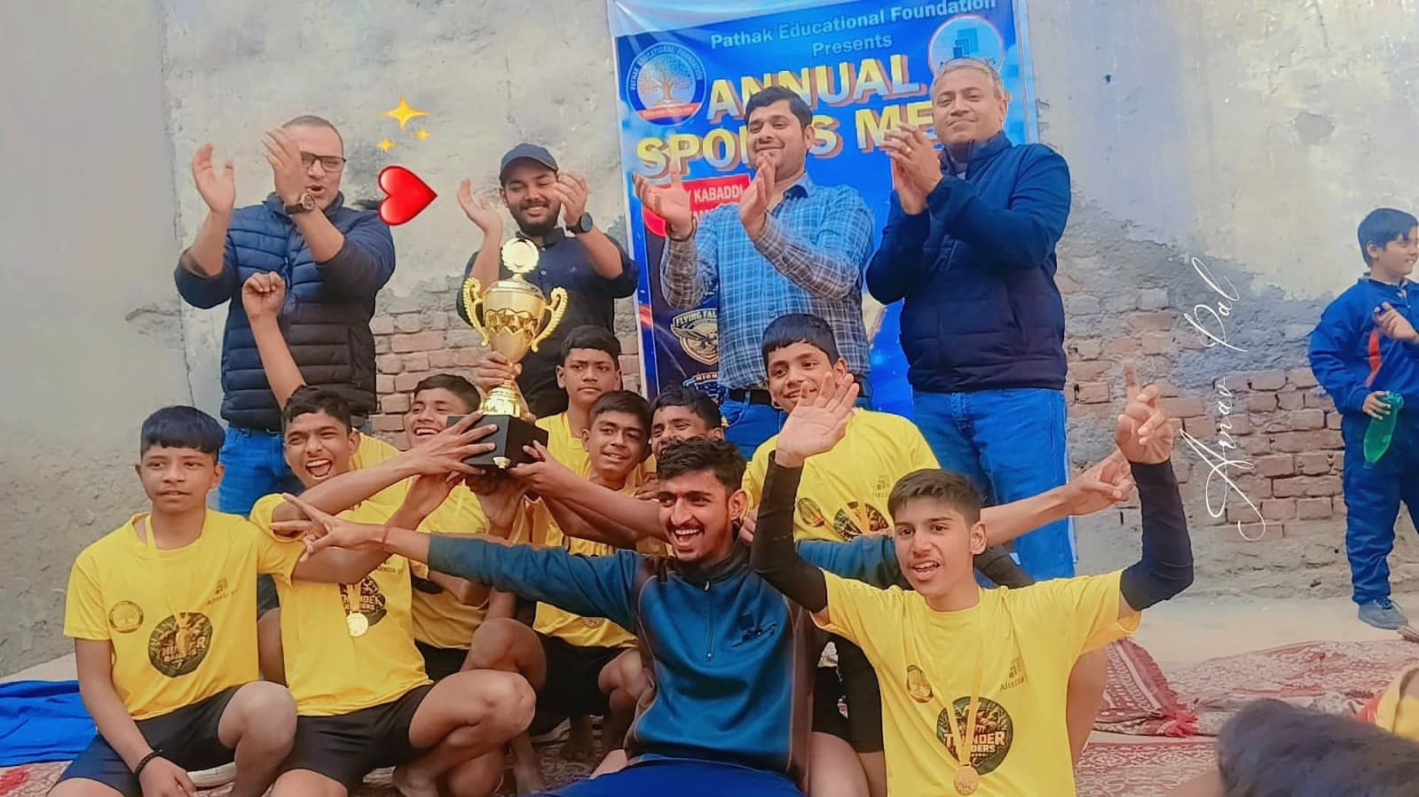 Students lifting a trophy at the annual sports meet