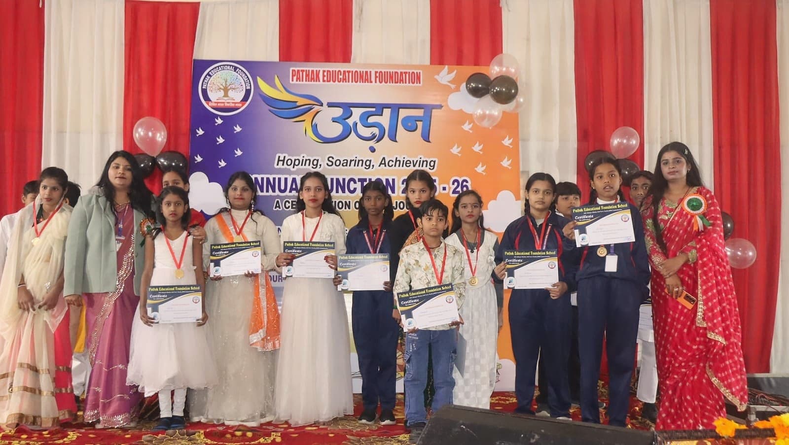 Students holding certificates and medals at a foundation prize ceremony